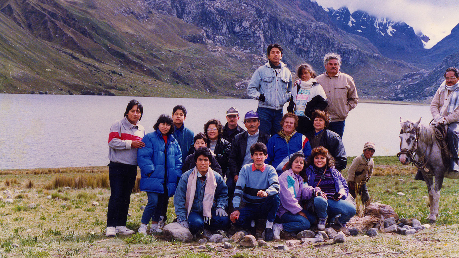 Grupo de personas ante una laguna en la sierra de Perú.]